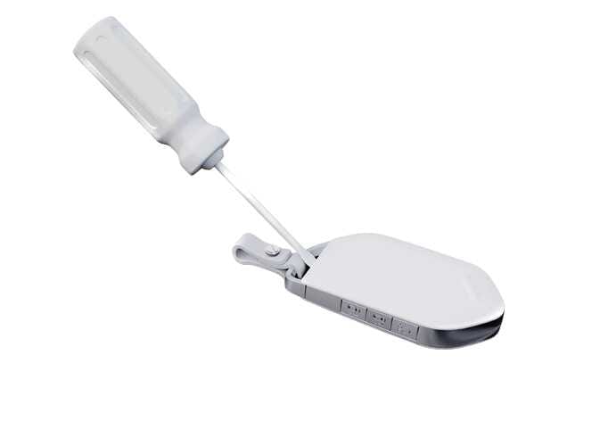 2026 Kia Tasman smart key battery replacement image. A thin tool is inserted into the slot at the top of the white smart key to pry open the battery cover. This illustrates the process of opening the cover to replace the battery.