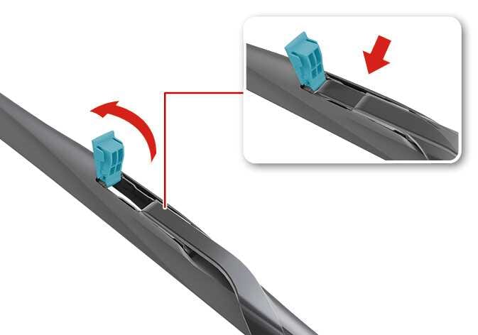 2026 Kia Tasman front wiper blade replacement image. A red curved arrow indicates lifting the cyan-highlighted clip on the wiper arm. An inset shows the clip raised and a red arrow pointing down to detach the blade. Explains how to unlock the clip and remove the wiper blade assembly.
