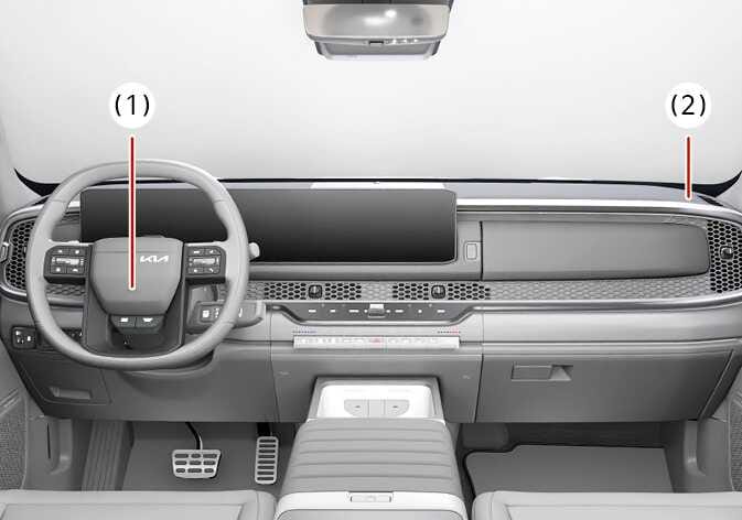 2026 Kia Tasman driver's and passenger's front air bags image. Red lines indicate the air bag locations at the center of the steering wheel (1) and the passenger's side front panel pad (2). Explains the location of the front air bag modules.