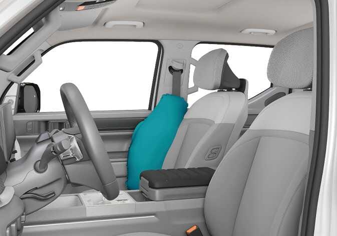 2026 Kia Tasman side air bag image. A side air bag highlighted in teal is shown deployed from the outer side of the driver's seat backrest next to the door. It explains the function of the side air bag providing protection for the driver during a side-impact collision.