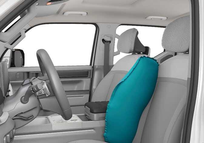 2026 Kia Tasman front center side air bag image. An airbag highlighted in teal is deployed from the inner side of the driver's seat backrest towards the center console area. It explains the function of the front center side air bag designed to inflate between the driver and front passenger to provide protection during a side impact.