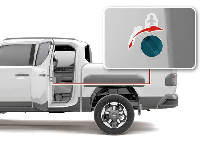 2026 Kia Tasman Child-protector rear door lock image. A magnified view shows the lock mechanism on the edge of the open rear door. A red curved arrow indicates turning the teal-highlighted slot towards the child symbol. This explains the function of activating the child safety lock.