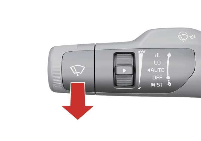 2026 Kia Tasman wiper control lever image. A red arrow points downwards from the lever handle, indicating the direction to pull the lever. The lever features a wiper icon and settings including MIST, OFF, AUTO, LO, and HI. This describes the function of spraying washer fluid on the windshield.