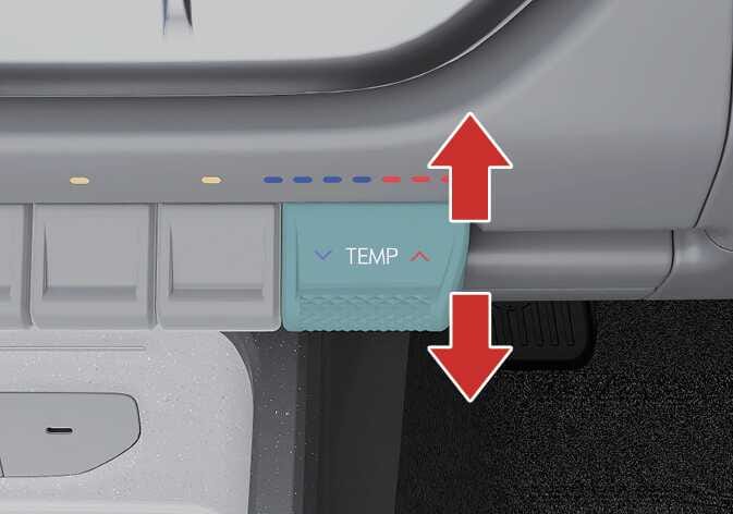 2026 Kia Tasman temperature control lever image. The teal-highlighted lever labeled 'TEMP' features red vertical arrows indicating up and down movement. Explains the function of adjusting air temperature by pushing the lever up for warm air or down for cool air.