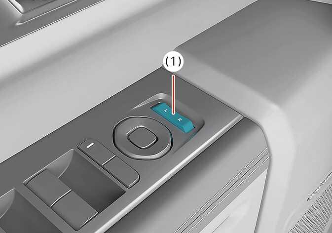 2026 Kia Tasman Outside rearview mirror select switch image. The switch labeled L and R is highlighted in teal and indicated by the number (1). Explains the function of setting the switch to the L or R position to enable the auto reverse mirror feature.