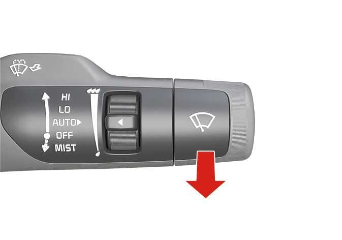 2026 Kia Tasman wiper control lever image. The lever displays HI, LO, AUTO, OFF, and MIST labels with a central adjustment dial. A red arrow points downwards from the handle marked with a wiper icon. This illustrates the operation for controlling the washers.