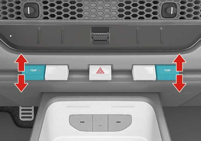 2026 Kia Tasman temperature control lever image. The 'TEMP' levers on the left and right are highlighted in teal, with thick red arrows pointing up and down indicating the direction of operation. Explains the function of adjusting the temperature by pressing the lever up or down.