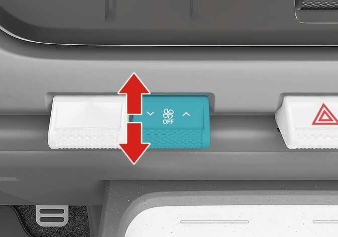 2026 Kia Tasman fan speed control lever image. A teal-highlighted lever on the center fascia features a fan icon with 'OFF' text, and a large red vertical double-headed arrow indicates the operation direction. Explains the function of adjusting the fan speed by pressing the lever up or down.