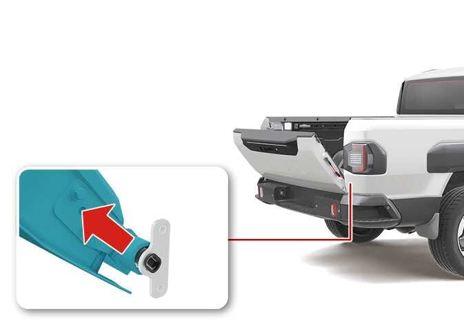 2026 Kia Tasman tailgate removal image. The tailgate is opened at a 45-degree angle. A close-up inset shows the right hinge area with the tailgate component highlighted in teal. A red arrow points diagonally upward, indicating the direction to detach the tailgate from the mounting bracket. Explains the process of removing the tailgate from the vehicle.