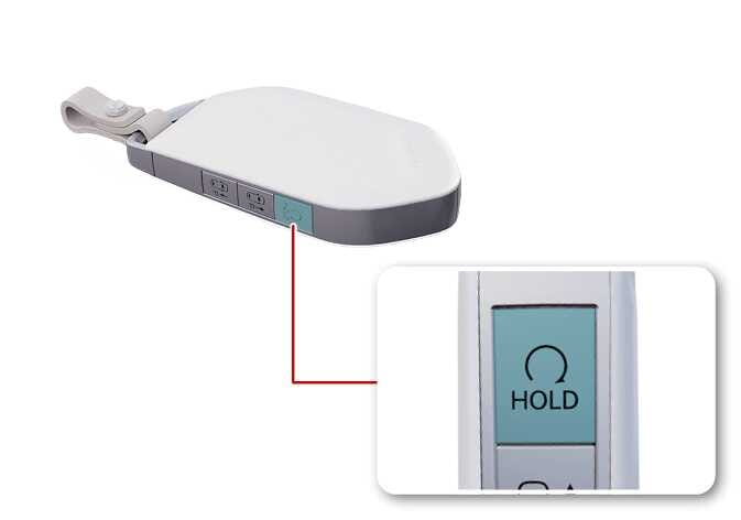 2026 Kia Tasman smart key remote start button image. The side button is highlighted in teal, with a magnified view showing the circular arrow icon and 'HOLD' text. Explains the function of pressing the button to remotely start the vehicle.