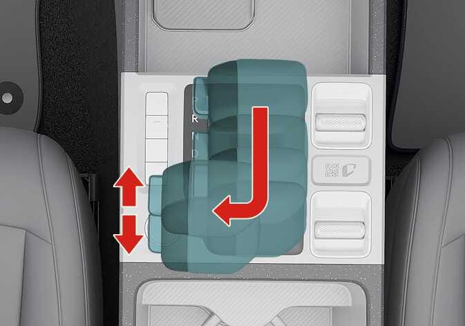 2026 Kia Tasman automatic transmission manual mode operation image. The gear shift lever is highlighted in teal with a red arrow indicating movement from the D position to the left manual gate. Vertical red arrows show pushing forward to upshift (+) and pulling backward to downshift (-). Explains the function of switching to manual mode and manually changing gears.