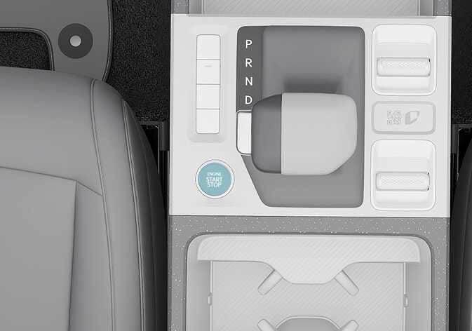 2026 Kia Tasman Engine Start/Stop button image. The image displays the center console layout where a circular button labeled 'ENGINE START STOP' is highlighted in cyan on the left. Adjacent to it is a gear selector handle with P, R, N, and D indicators. Explains the location of the button used to start or stop the vehicle.