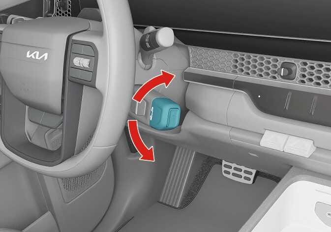 2026 Kia Tasman SBW type shift lever image. The shift lever located on the right side of the steering column is highlighted in teal. Red curved arrows indicate the direction to rotate the lever up or down. Explains the function of changing gears by turning the lever.