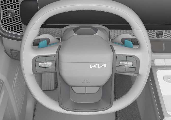 2026 Kia Tasman paddle shifter image. The paddle shifters located behind the left and right sides of the steering wheel are highlighted in teal. Describes the function of manually shifting gears up or down by pulling the levers.