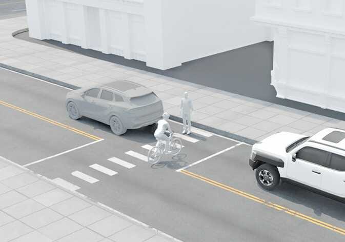 2026 Kia Tasman Driver Attention Warning limitation image. A white vehicle is approaching a crosswalk where a pedestrian and a cyclist are crossing, while a grey vehicle in the opposite lane is stopped. This illustrates a situation where the Driver Attention Warning system may not operate properly.