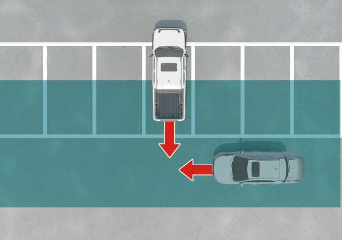 2026 Kia Tasman Rear Cross-Traffic Collision-Avoidance Assist limitation image. A top-down view shows a white truck backing out and a grey car approaching from the right, indicated by red arrows. The rear lane is highlighted in teal. Explains a scenario where a vehicle approaches from the side while reversing.