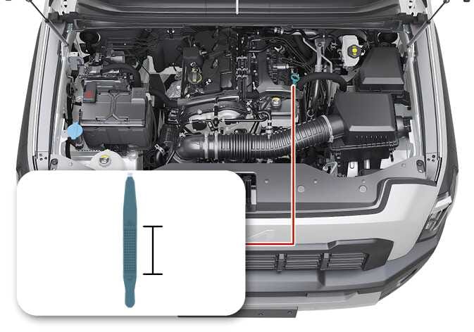 2026 Kia Tasman Smartstream G2.5 T-GDi engine compartment image. The engine oil dipstick is highlighted in teal. A red line connects the dipstick location to a detailed inset showing the dipstick tip with a textured pattern and a bracket indicating the measurement range. This explains the location of the dipstick and the specific area used to check the engine oil level.