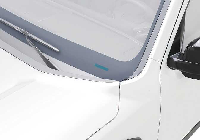 2026 Kia Tasman VIN location image. A rectangular area highlighted in teal at the bottom of the front windshield indicates the VIN plate position. Explains where to locate the VIN visible from the vehicle exterior.