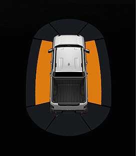2026 Kia Tasman Side Parking Distance Warning image. A top-down view of the vehicle shows orange warning zones on the left and right sides. This explains the warning function when an object is detected within 30 to 60 cm (12 to 24 in).