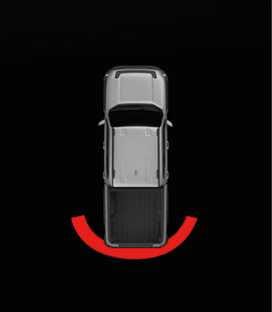 2026 Kia Tasman Reverse Parking Distance Warning infotainment display image. A top-down view of the vehicle shows a solid red arc behind the rear bumper, indicating an object is detected within 30 cm (12 in). It explains the visual warning function on the infotainment screen.