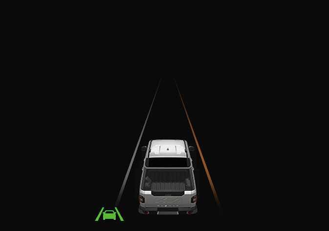 2026 Kia Tasman Lane Keeping Assist warning display image. A white vehicle is depicted with the right lane line highlighted in orange, while a green system icon appears at the bottom left. Explains the function of warning the driver and assisting control when the vehicle approaches a lane marker.