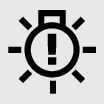 2026 Kia Tasman LED Headlamp warning light icon. A symbol depicting a light bulb with an exclamation mark inside and radiating lines. Explains the function of indicating a malfunction in the LED headlamp system.