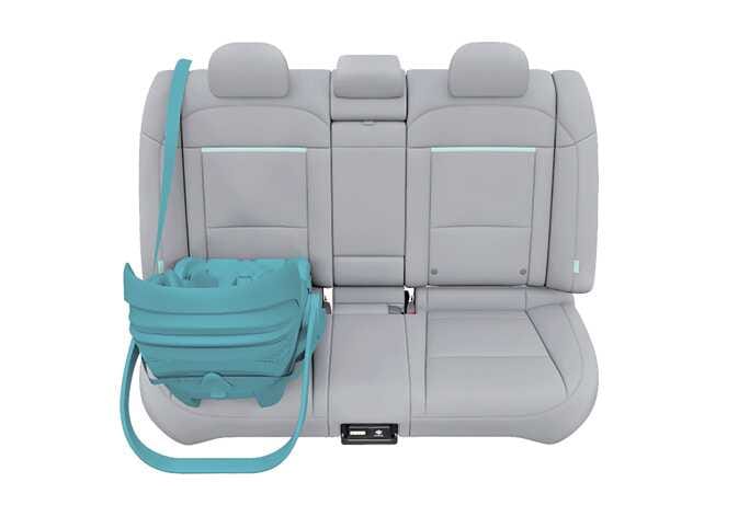 2026 기아 타스만 뒷좌석 어린이 보조 시트 장착 이미지입니다. 차량 뒷좌석에 놓인 어린이 보조 시트와 이를 감싸는 안전벨트 경로가 청록색으로 강조되어 있습니다. 안전벨트가 보조 시트의 지정된 가이드를 통과하여 체결된 모습을 보여줍니다. ALR 3점식 안전벨트를 사용하여 어린이 보조 시트를 차량에 안전하게 고정하는 준비 단계를 설명합니다.