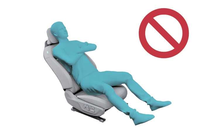 2026 기아 타스만 동승석 승객 구분 시스템 주의사항 이미지입니다. 청록색으로 강조된 탑승자가 팔짱을 끼고 엉덩이를 앞으로 빼 시트에 비스듬히 기대어 앉은 모습과 붉은색 금지 기호가 표시되어 있습니다. 승객 구분 시스템 작동에 방해가 될 수 있는 올바르지 않은 착석 자세를 경고하는 기능을 설명합니다.