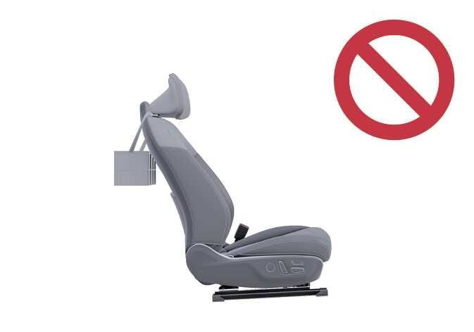 2026 기아 타스만 헤드레스트 액세서리 장착 금지 이미지입니다. 시트 헤드레스트 후면에 별도의 거치대 액세서리가 부착된 모습과 우측 상단에 붉은색 금지 기호가 표시되어 있습니다. 헤드레스트 지지대에 옷걸이 등의 액세서리를 장착하면 안 된다는 주의 사항을 설명합니다.