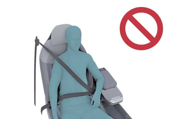 2026 기아 타스만 동승석 승객 구분 시스템 주의사항 이미지입니다. 청록색으로 강조된 탑승자가 안전벨트 어깨띠를 팔 겨드랑이 아래로 착용한 모습과 우측 상단에 붉은색 금지 기호가 표시되어 있습니다. 시스템 작동을 방해하는 올바르지 않은 안전벨트 착용 방법을 경고하는 기능을 설명합니다.