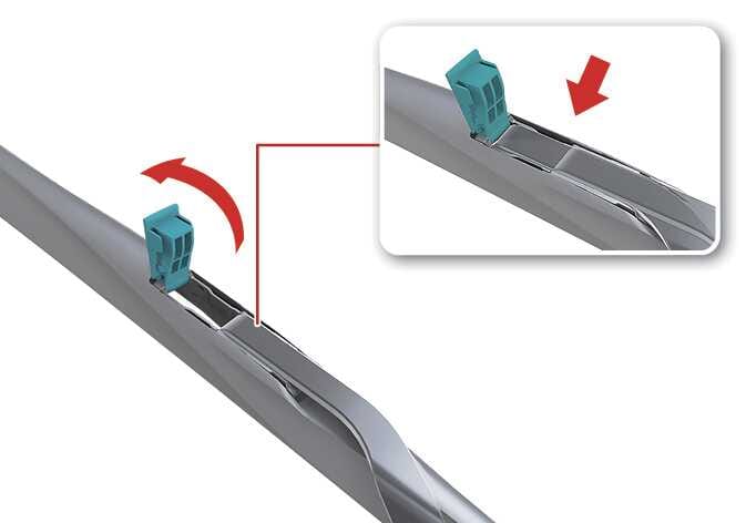 2026 기아 타스만 와이퍼 블레이드 분리 이미지입니다. 청록색으로 강조된 잠금쇠를 위로 들어 올리는 붉은색 굽은 화살표와, 잠금쇠가 열린 상태에서 블레이드를 아래 방향으로 내리는 붉은색 직선 화살표가 표시되어 있습니다. 잠금쇠를 세우고 블레이드를 아래로 내려 와이퍼 암에서 분리하는 과정을 설명합니다.