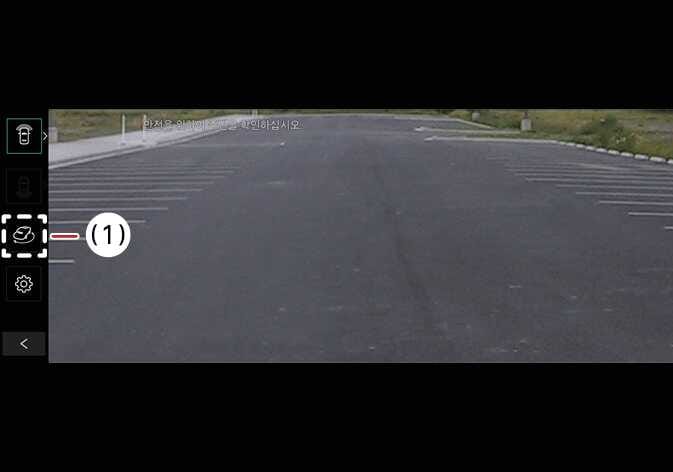 2026 기아 타스만 3D 뷰 선택 버튼 이미지입니다. 서라운드 뷰 모니터 화면 좌측 메뉴바에서 자동차 모양의 아이콘이 (1)번으로 표시되어 있고 점선 박스로 강조되어 있습니다. 화면의 버튼을 선택하여 3D 뷰 기능을 켜는 작동 방법을 설명합니다.