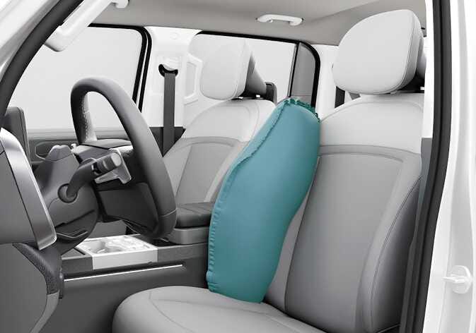 2026 기아 타스만 앞좌석 센터 사이드 에어백 이미지입니다. 운전석 우측 등받이에서 전개된 에어백이 청록색으로 강조되어 운전석과 센터 콘솔 사이를 가리고 있는 모습입니다. 사고 발생 시 운전자와 동승자 간의 충돌을 방지하고 차량 내장 부품과의 충돌 충격을 줄여주는 기능을 설명합니다.