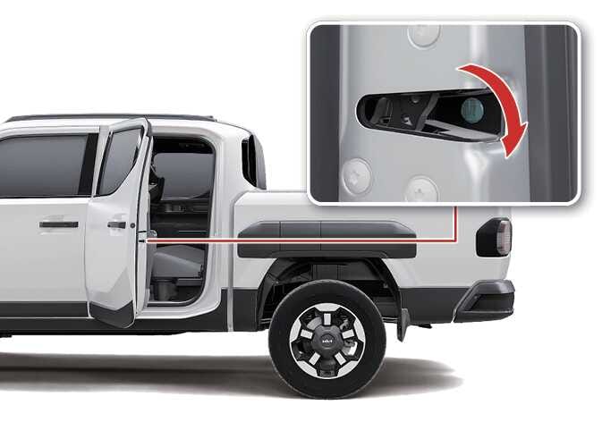 2026 기아 타스만 비상시 도어 잠금 방법 이미지입니다. 뒷좌석 도어가 열려 있고, 도어 측면의 잠금 장치 위치를 확대한 상세도가 포함되어 있습니다. 상세도에는 비상 키를 꽂아 차량 안쪽으로 돌리는 동작을 붉은색 굽은 화살표로 안내하고 있습니다. 배터리 방전 시 수동으로 도어를 잠그는 기능을 설명합니다.