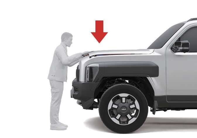 2026 기아 타스만 엔진 후드 닫기 이미지입니다. 차량 전면부 앞에서 사람이 엔진 후드 앞부분을 양손으로 누르는 모습과, 아래 방향을 가리키는 굵은 빨간색 화살표가 표시되어 있습니다. 엔진 후드를 내린 후 아래로 눌러 확실하게 닫는 기능을 설명합니다.