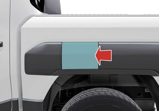 2026 기아 타스만 연료 주입구 개폐 방법 이미지입니다. 차량 후측면 휠 아치 상단에 위치한 연료 주입구 커버가 청록색으로 강조되어 있습니다. 왼쪽을 가리키는 굵은 빨간색 화살표가 커버의 가장자리를 지시하고 있습니다. 화살표 방향으로 커버를 눌러 연료 주입구를 여는 기능을 설명합니다.