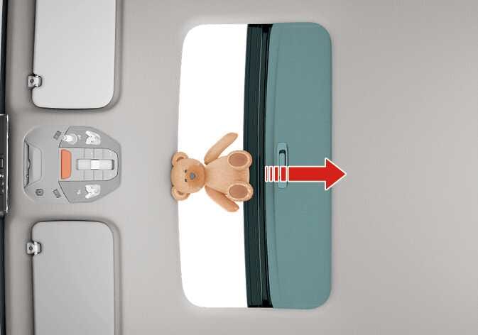 2026 기아 타스만 선루프 물체 끼임 인식 기능 이미지입니다. 청록색으로 강조된 선루프 글라스와 루프 패널 사이에 곰 인형이 끼어 있는 모습입니다. 붉은색 화살표가 선루프가 닫히는 방향을 가리키고 있습니다. 선루프가 닫히는 중 물체가 감지되면 작동을 멈추고 되돌아가는 안전 기능을 설명합니다.