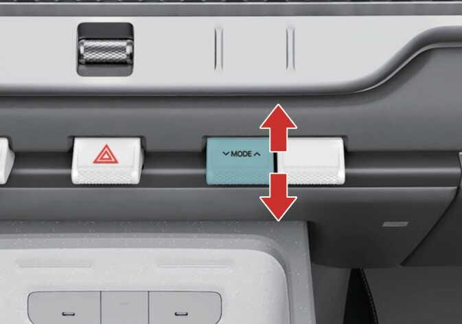 2026 기아 타스만 바람 방향 선택 레버 이미지입니다. 비상등 버튼 우측에 위치한 'MODE' 문구가 표기된 스위치가 청록색으로 강조되어 있습니다. 스위치 위아래로 뻗은 붉은색 수직 화살표는 조작 방향을 지시합니다. 레버를 위아래로 움직여 원하는 위치로 바람의 방향을 조절하는 기능을 설명합니다.