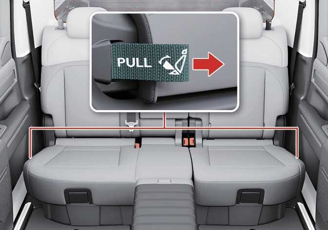 2026 기아 타스만 시트 하단 보관함 이미지입니다. 뒷좌석 시트 하단 영역이 붉은색 선으로 강조되어 있습니다. 상단 확대 이미지에는 'PULL' 문구와 시트 조작 아이콘이 그려진 스트랩이 보이며, 붉은색 화살표가 당기는 방향을 지시합니다. 스트랩을 당겨 시트 쿠션을 들어 올리고 하단 보관함을 사용하는 방법을 설명합니다.