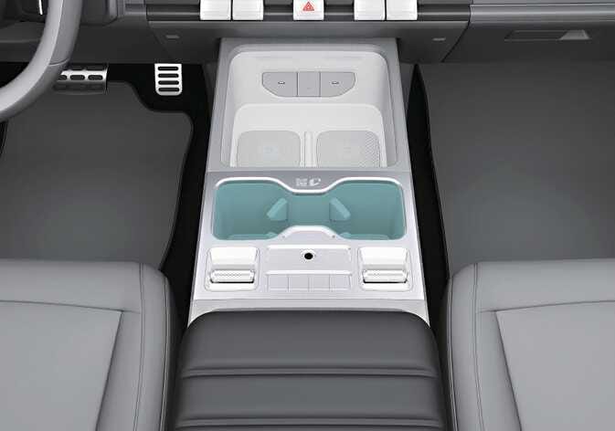 2026 기아 타스만 앞좌석 컵 홀더 이미지입니다. 센터 콘솔 중앙에 위치한 두 개의 컵 홀더가 청록색으로 강조되어 있습니다. 음료가 담긴 컵이나 캔 등을 보관할 수 있는 앞좌석 컵 홀더의 위치를 설명합니다.