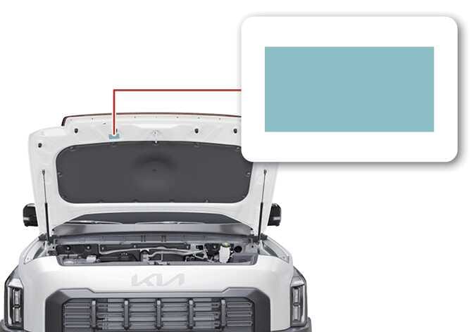 2026 기아 타스만 에어컨 냉매 사양 라벨 위치 이미지입니다. 차량의 후드가 열려 있고, 후드 안쪽 상단 중앙에 위치한 라벨을 붉은색 선으로 연결하여 확대해 보여줍니다. 청록색으로 강조된 사각형은 냉매 종류와 용량을 확인할 수 있는 사양 라벨의 부착 위치를 설명합니다.