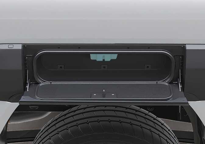 2026 기아 타스만 사이드 스토리지 이미지입니다. 뒷바퀴 상단에 위치한 사이드 스토리지가 열려 있고, 내부 상단의 잠금 장치 체결 부위가 청록색으로 강조되어 있습니다. 세차 시 물줄기를 집중해서 분사하면 고장이 발생할 수 있는 전자 장비의 위치를 설명합니다.