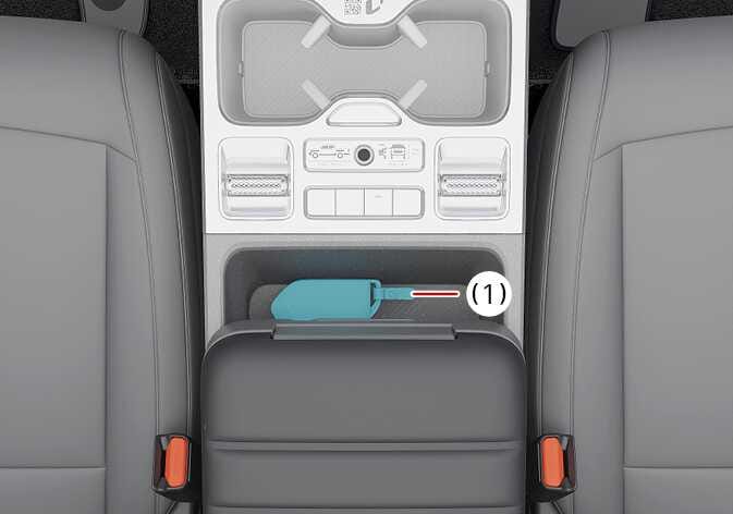 2026 기아 타스만 스마트 키 인식 위치 이미지입니다. 센터 콘솔 박스 내부의 특정 공간(1)에 청록색으로 강조된 스마트 키가 놓여 있으며, 붉은색 화살표가 해당 위치를 지시하고 있습니다. 시동이 걸리지 않을 때 스마트 키를 해당 위치에 올려놓고 시동 버튼을 눌러 시동을 거는 방법을 설명합니다.