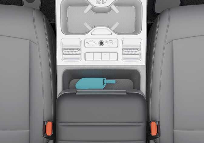 2026 기아 타스만 스마트 키 인식 위치 이미지입니다. 중앙 콘솔 박스 앞쪽 수납 공간에 청록색으로 강조된 스마트 키가 놓여 있습니다. 스마트 키가 인식되지 않을 때 시동을 걸기 위해 키를 두어야 하는 정확한 위치를 설명합니다.