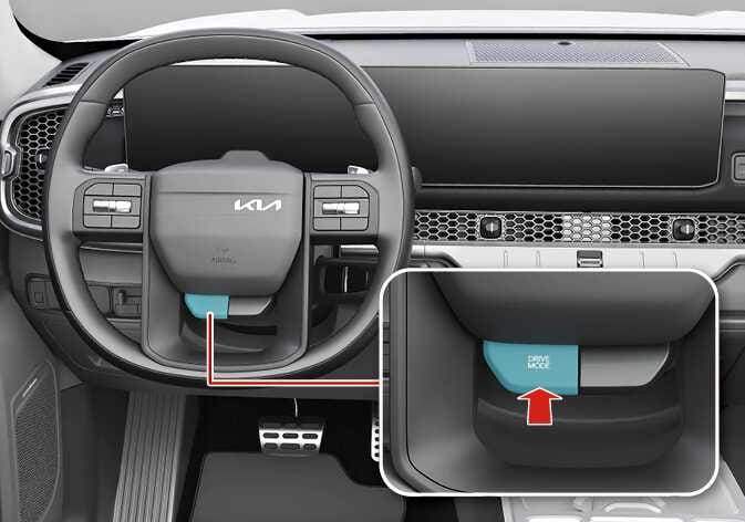 2026 기아 타스만 TOW 모드 작동 버튼 이미지입니다. 스티어링 휠 좌측 하단에 청록색으로 강조된 버튼이 위치해 있으며, 연결된 상세도에는 'DRIVE MODE' 문구가 적힌 버튼을 가리키는 붉은색 화살표가 표시되어 있습니다. 스티어링 휠의 드라이브 모드 버튼을 길게 눌러 TOW 모드를 켜거나 끄는 기능을 설명합니다.