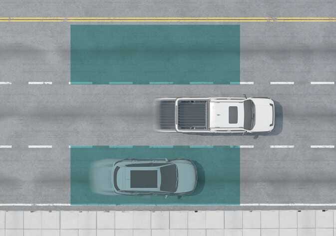 2026 기아 타스만 후측방 충돌방지 보조(BCA) 작동 이미지입니다. 3차로 도로의 중앙 차선에서 주행 중인 흰색 차량의 좌우 후측방 영역이 청록색 사각형으로 강조되어 있습니다. 우측 후측방의 청록색 영역 내에 회색 차량이 위치해 있어 감지된 상태를 보여줍니다. 사각 지대에 위치한 차량을 인식하여 운전자에게 알려주는 기능을 설명합니다.