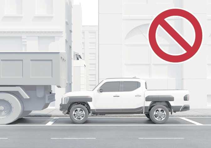 2026 기아 타스만 원격 스마트 주차 보조 작동 제한 이미지입니다. 흰색 타스만 차량이 적재함 높이가 높은 대형 트럭 뒤에 정차해 있는 모습과 우측 상단에 붉은색 원형 금지 기호가 표시되어 있습니다. 적재함의 높이가 높거나 큰 차량 주변에서는 원격 스마트 주차 보조 기능 사용을 제한해야 함을 설명합니다.