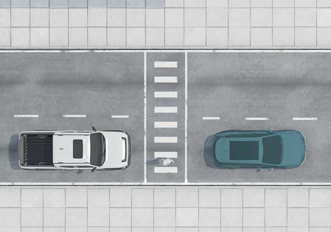 2026 기아 타스만 스마트 크루즈 컨트롤 작동 제한 상황 이미지입니다. 흰색 트럭과 옆 차로 차량 전방의 횡단보도를 건너는 보행자가 보입니다. 보행자가 있는 횡단보도 주변에서 시스템 작동이 제한될 수 있는 상황을 설명합니다.