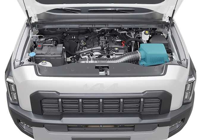 2026 기아 타스만 엔진룸 내부 에어클리너 이미지입니다. 후드가 열린 상태에서 엔진룸 우측에 위치한 에어클리너 박스와 연결 호스가 청록색으로 강조되어 있습니다. 정기 점검 시 에어클리너 필터의 위치를 확인하는 기능을 설명합니다.