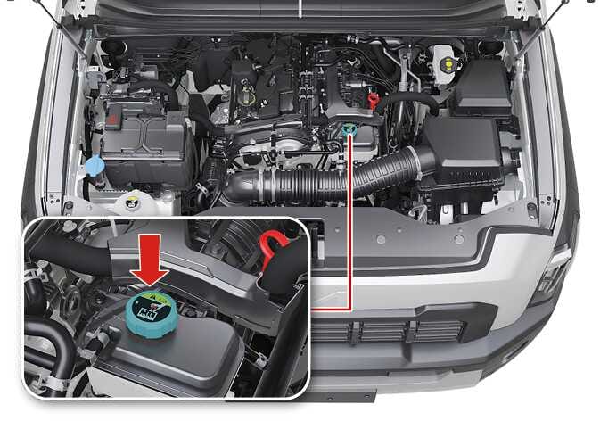 2026 기아 타스만 인터쿨러 냉각수 리저버 탱크 이미지입니다. 엔진룸 내부의 탱크 위치와 청록색으로 강조된 리저버 탱크 캡을 확대한 상세도가 포함되어 있습니다. 캡 상단에는 굵은 빨간색 화살표가 아래쪽을 가리키고 있으며, 캡 표면의 스티커가 정면을 향해 있습니다. 냉각수 보충 후 캡이 정상적으로 안착되었는지 확인하는 위치를 설명합니다.